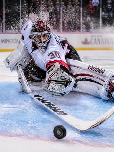 ice_hockey_goalie_making_dramatic_save_with_ice_spray